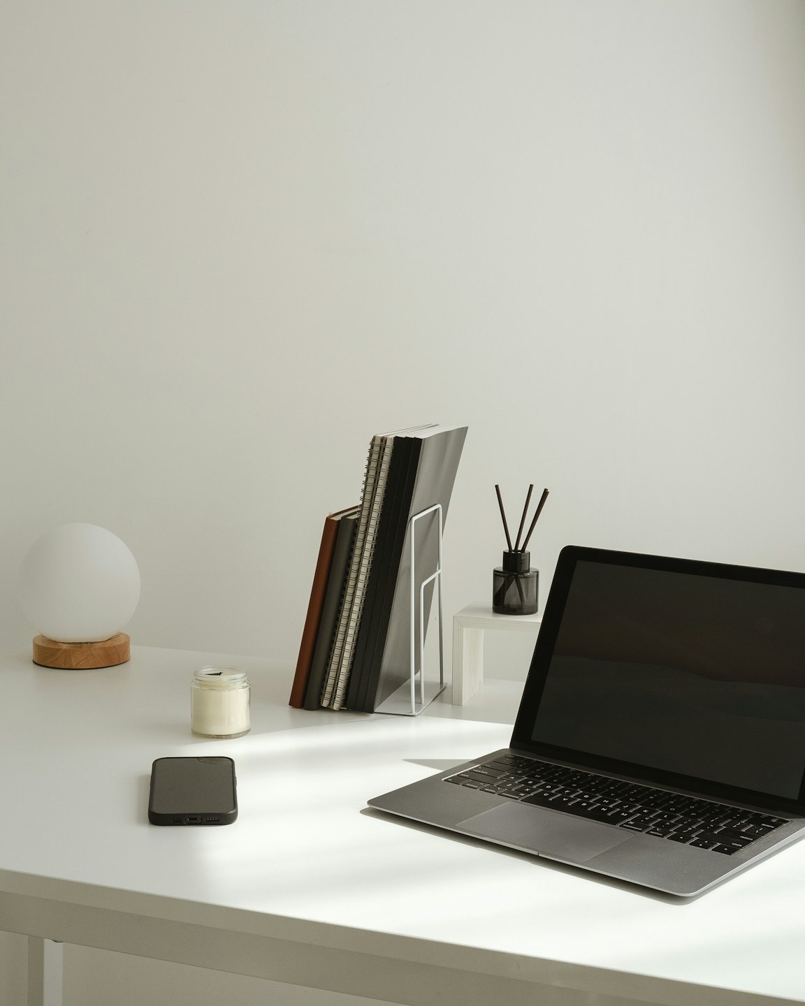 Laptop and desk accessories arranged neatly on a wooden desk.