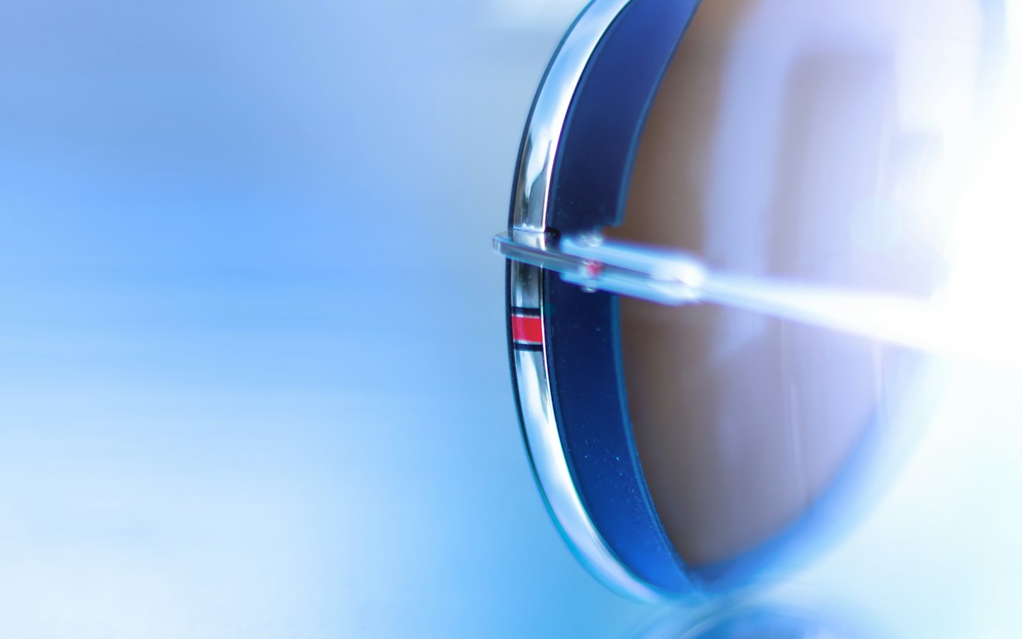 Close-up of sunglasses hinge with red stripe detail.